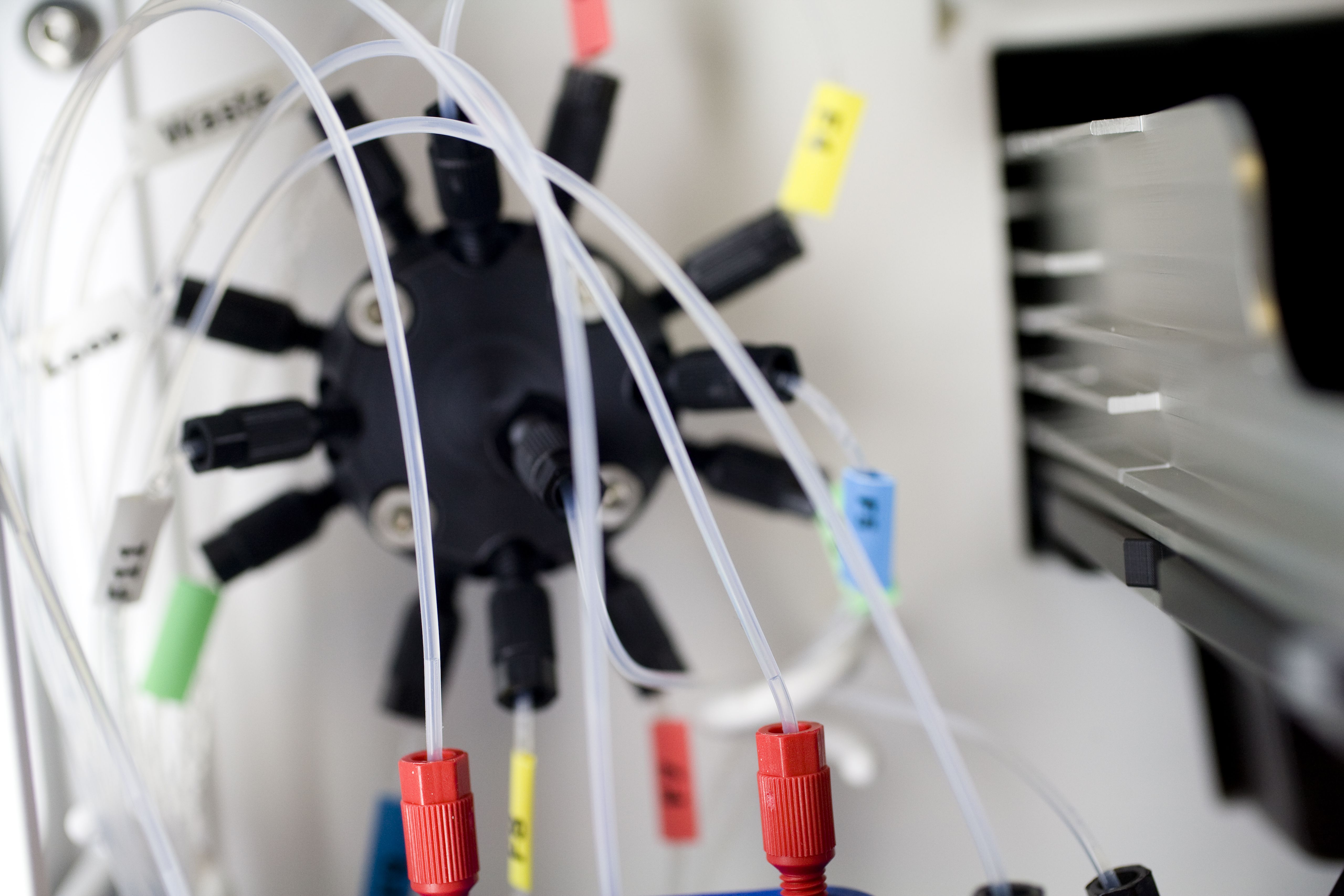 Instrumento científico con tubos transparentes conectados a tornillos rojos