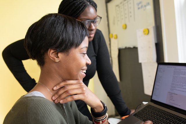 Two black women looking at a computer screen