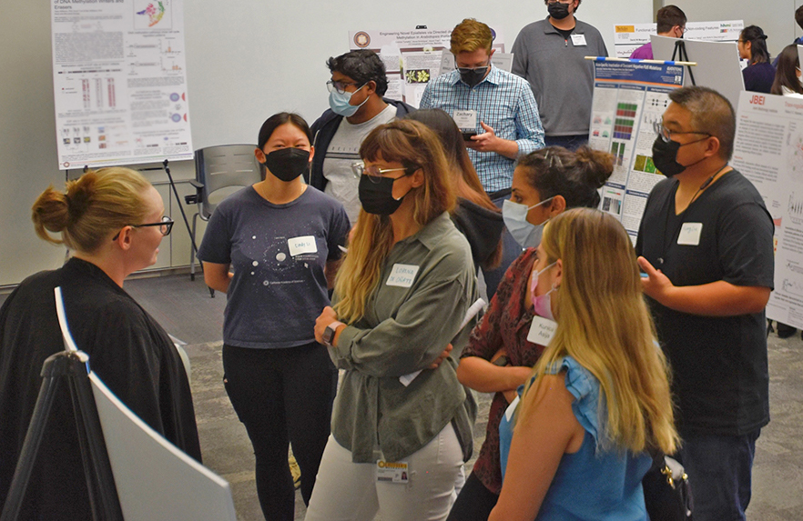 Bethany Kolody (left) explains her work on studying the microbial sources of methane emissions from rice fields