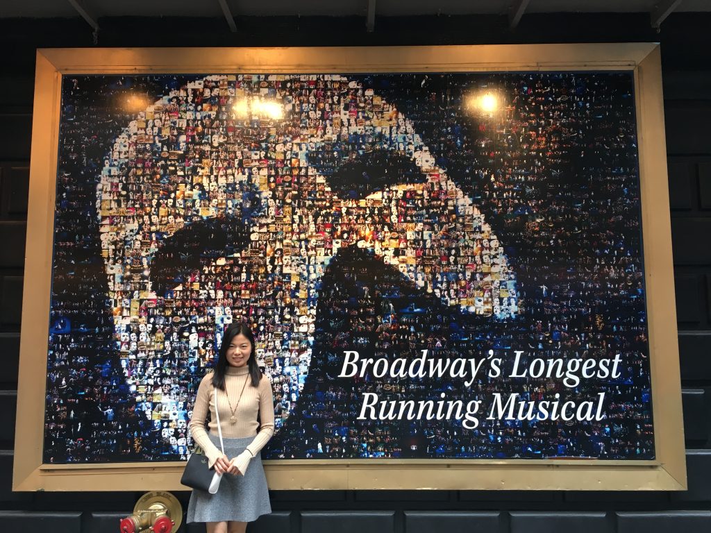 Lin Du frente a un cartel de Broadway