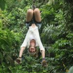 Kelsey Hern colgando boca abajo, haciendo tirolesa en Costa Rica