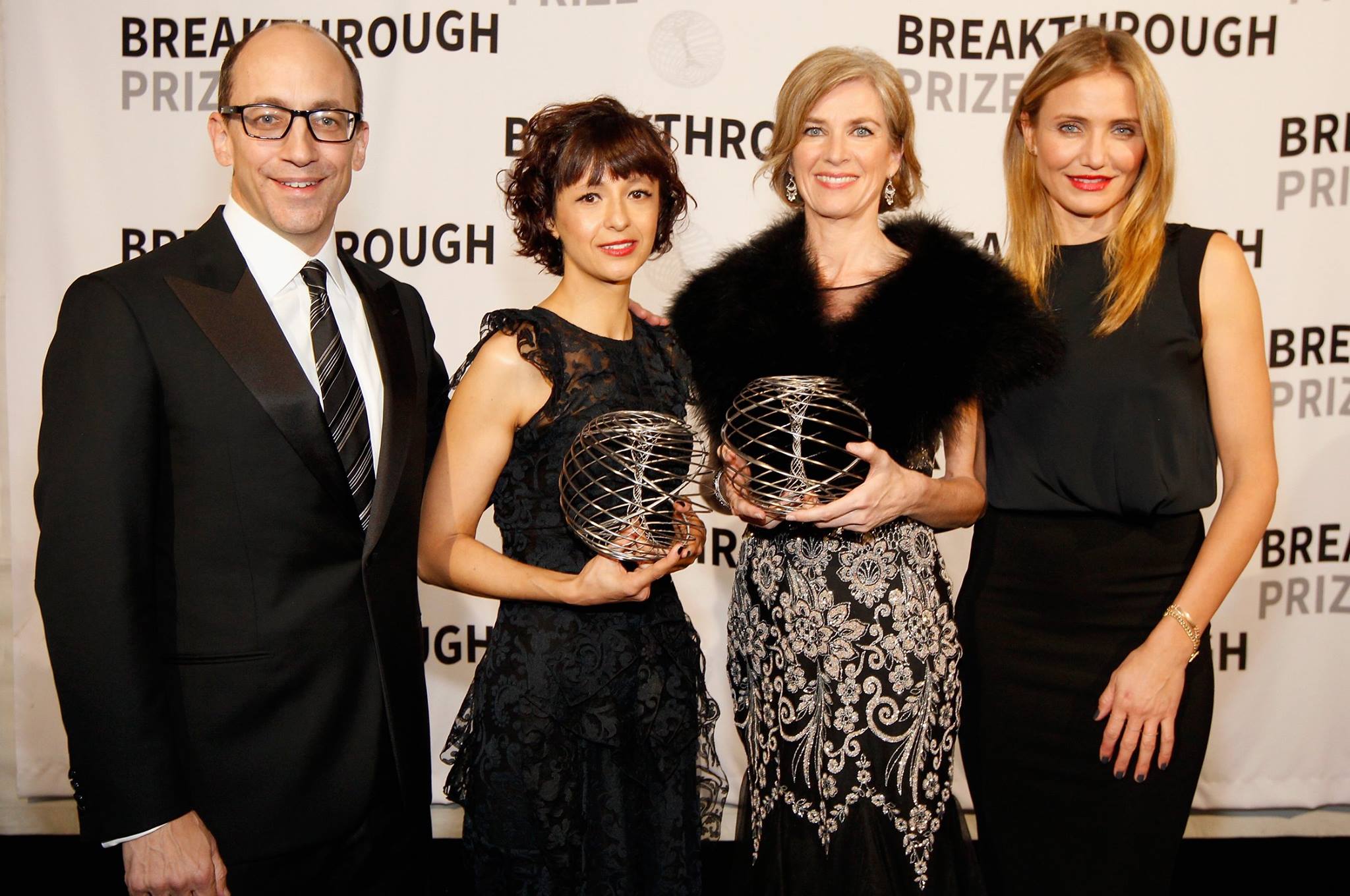 Emmanuelle Charpentier and Jennifer Doudna holding Breakthrough Prize awards and standing next to Cameron Diaz