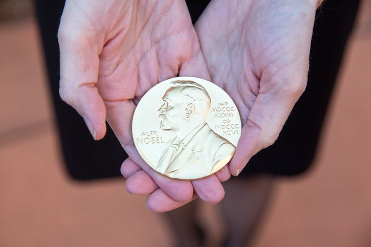 Closeup of the gold Nobel Prize medal in Jennifer Doudna's hand