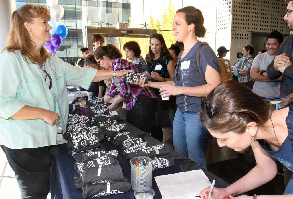 IGI staff handing out shirts at the Open House