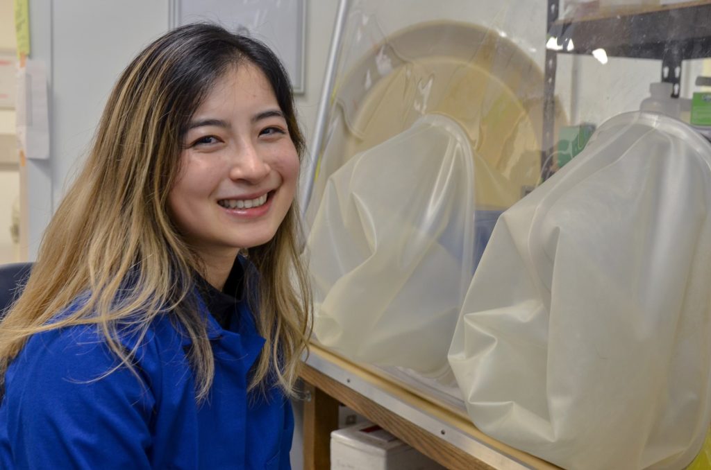 Yue Clare Lou sitting by an anaerobic chamber