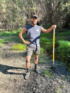 Luis Valentin-Alvarado standing in a field with a shovel