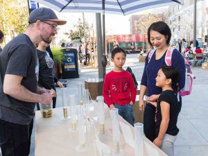 photo of Kevin Doxzen doing coin voting activity with children