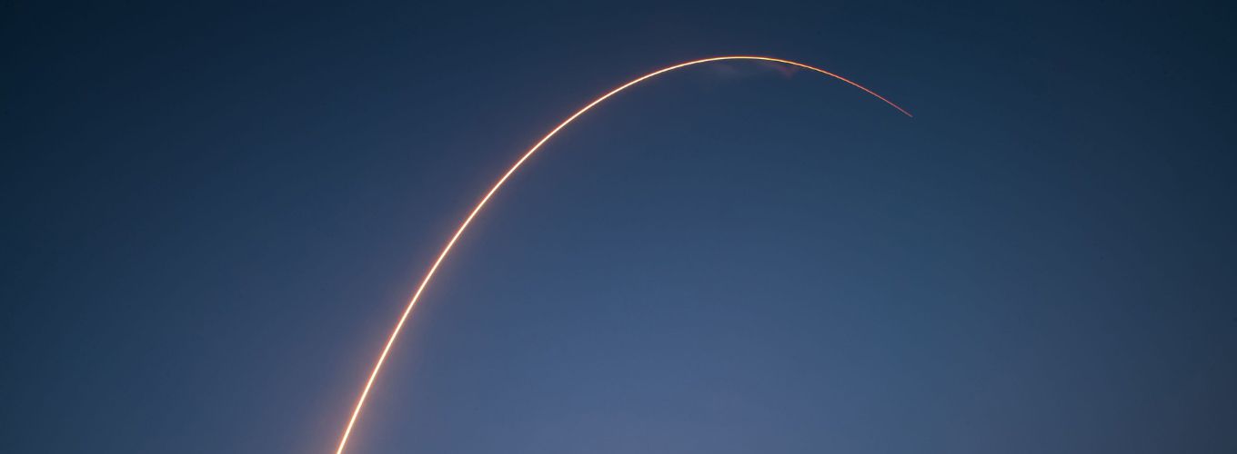 Bright arcing trail from a rocket in the night sky