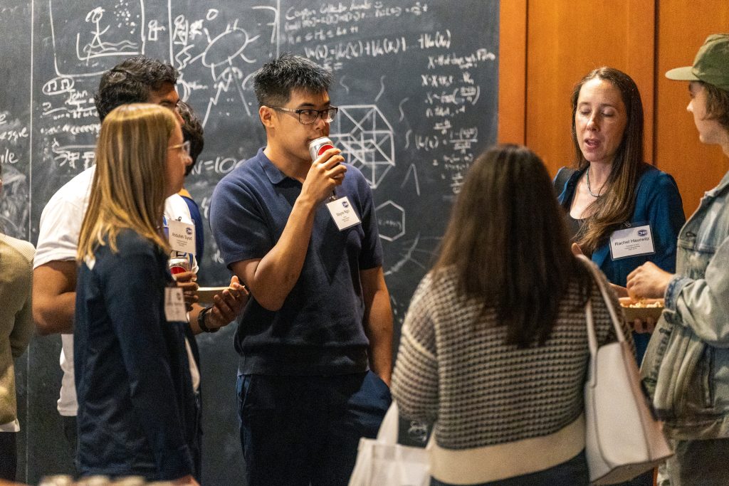 a group of researchers in front of a blackboard