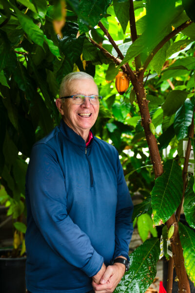 Brian Staskawicz standing with a cacao plant